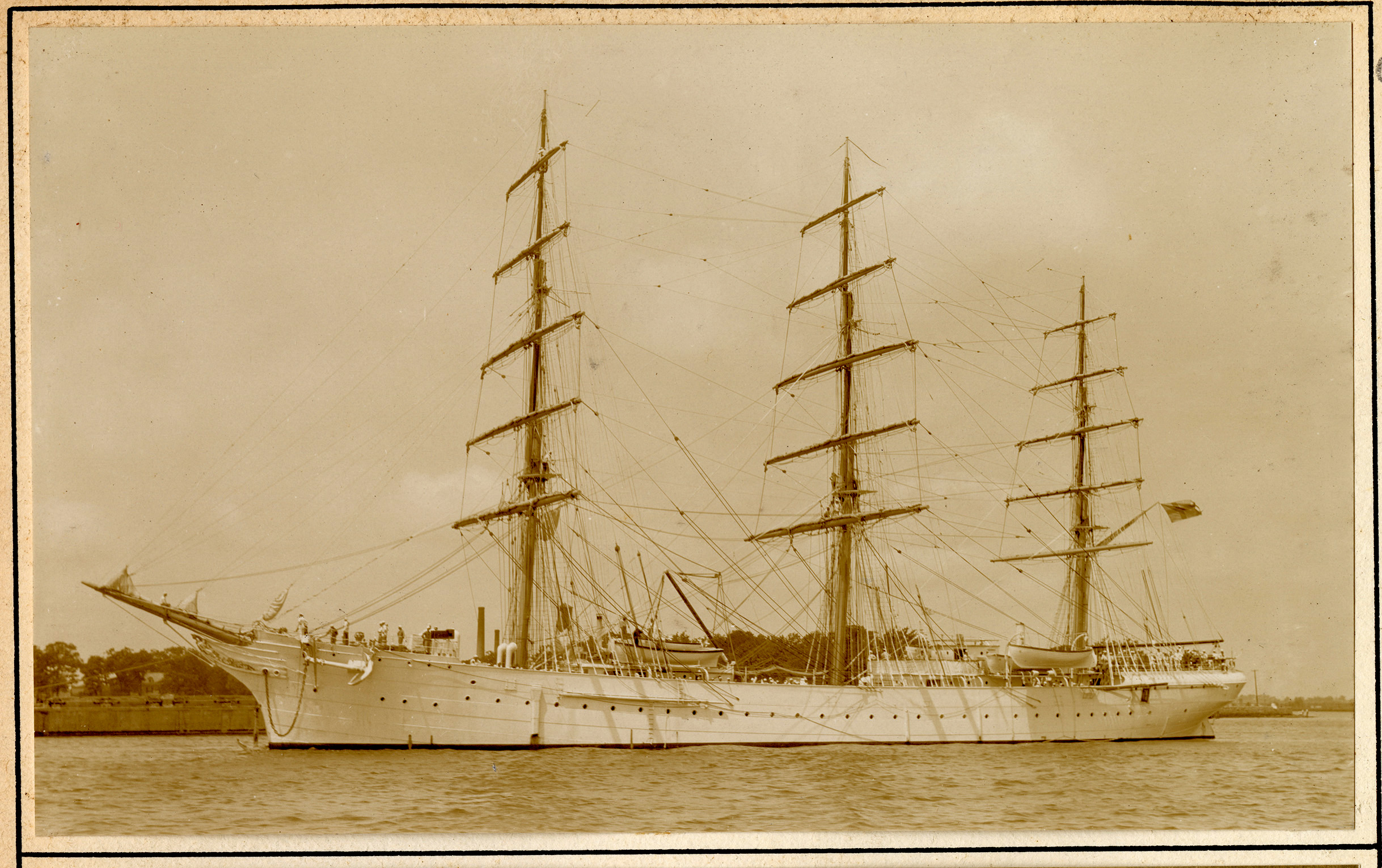 Three-masted sailing ship alongside a quay